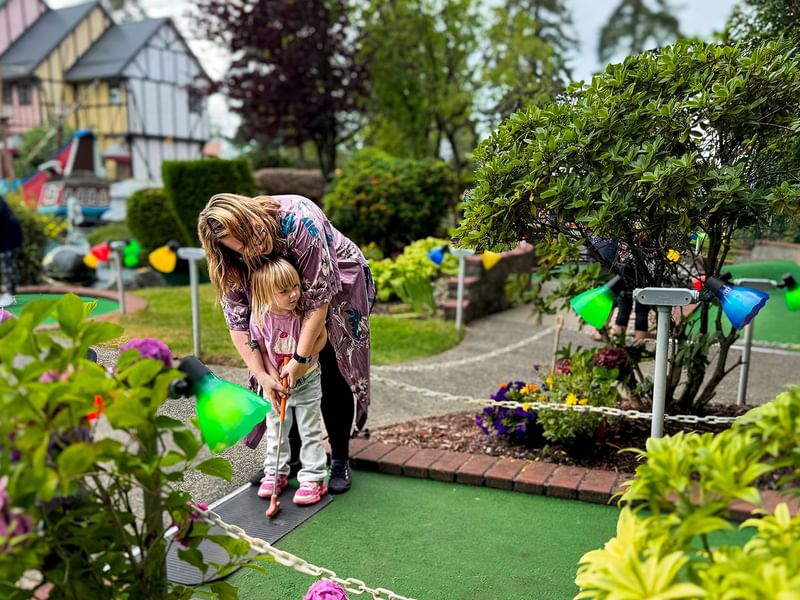 Mother and child playing mini golf