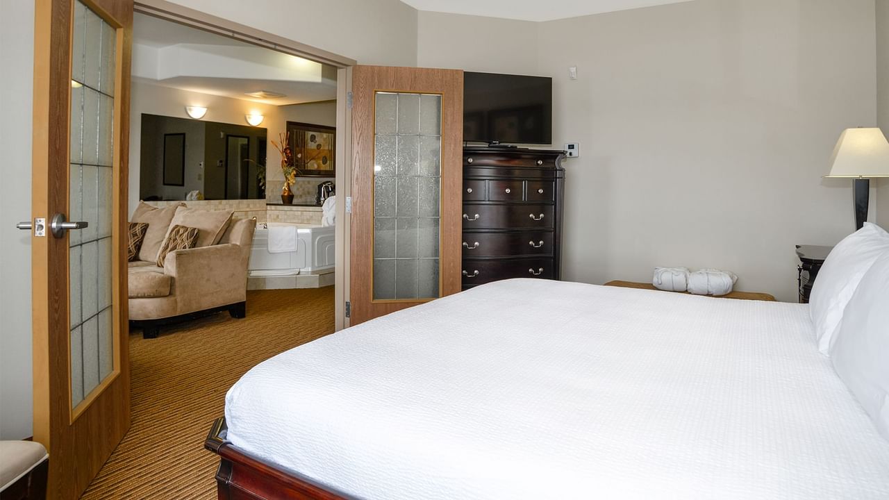 Hotel suite with a king bed and separate living room with jetted tub