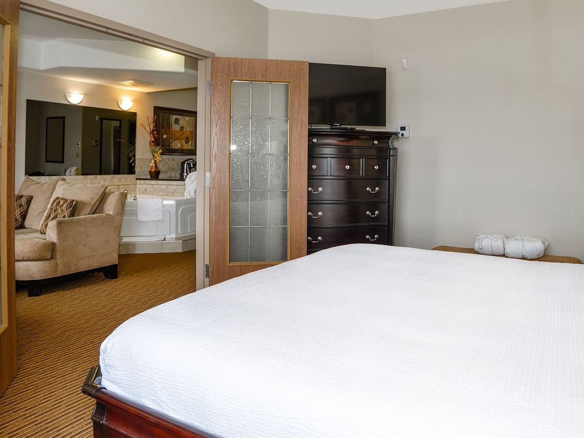 Hotel suite with a king bed and separate living room with jetted tub