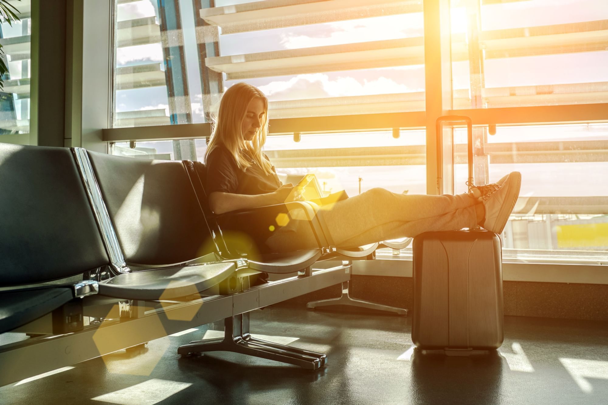 Portrait of a girl using a phone with luggage at Los Cabos