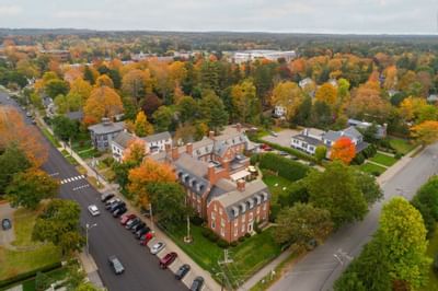 Aerial view of The Exeter Inn with lush green lawn and colorful autumn trees nearby