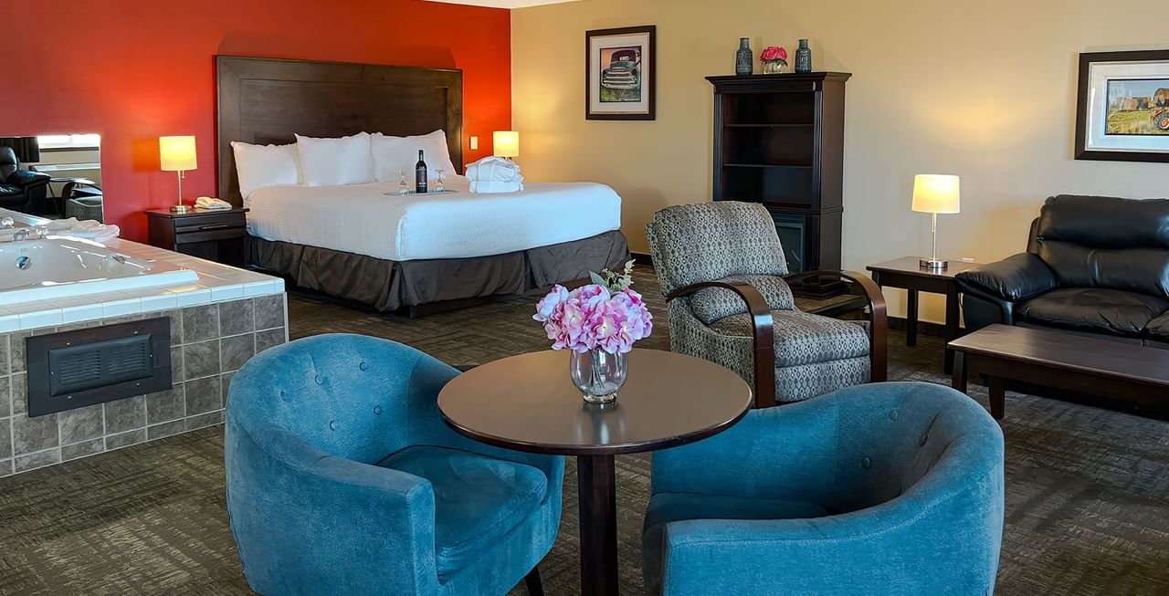 Bed, lounge couches, and a jacuzzi in a hotel suite