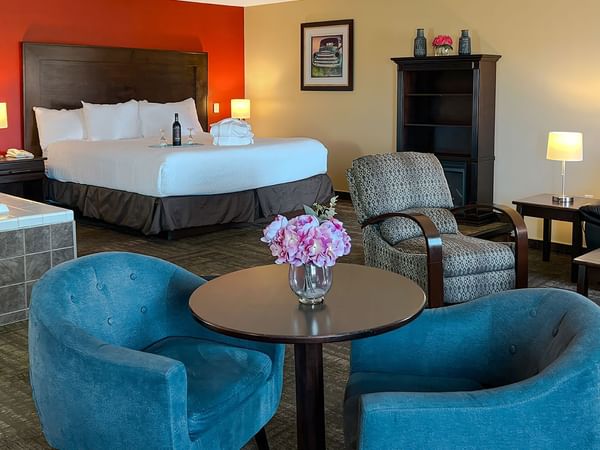 Jacuzzi tub, bed, couches, and tables in hotel suite