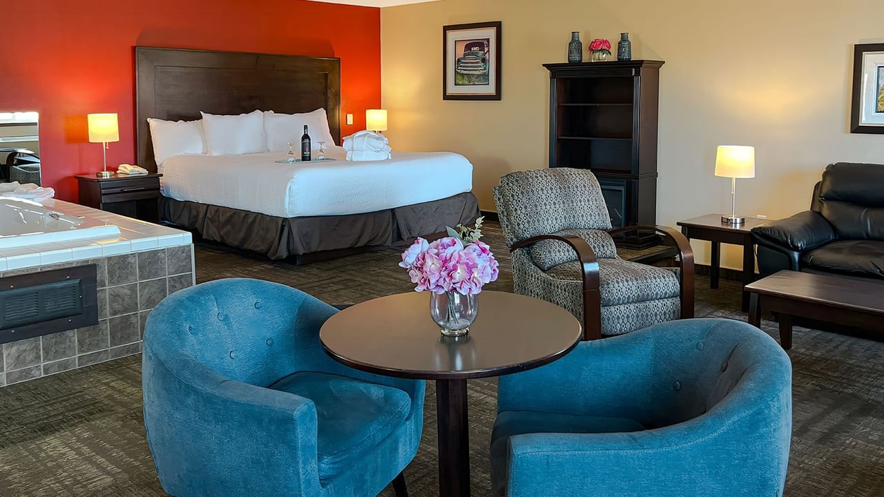 Jacuzzi tub, bed, couches, and tables in hotel suite