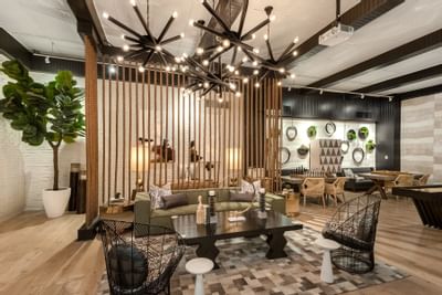 24-Hour Lounge with Games featuring stylish furniture, a lush wall decor, and wooden floors at The Riverwalk Plaza Hotel