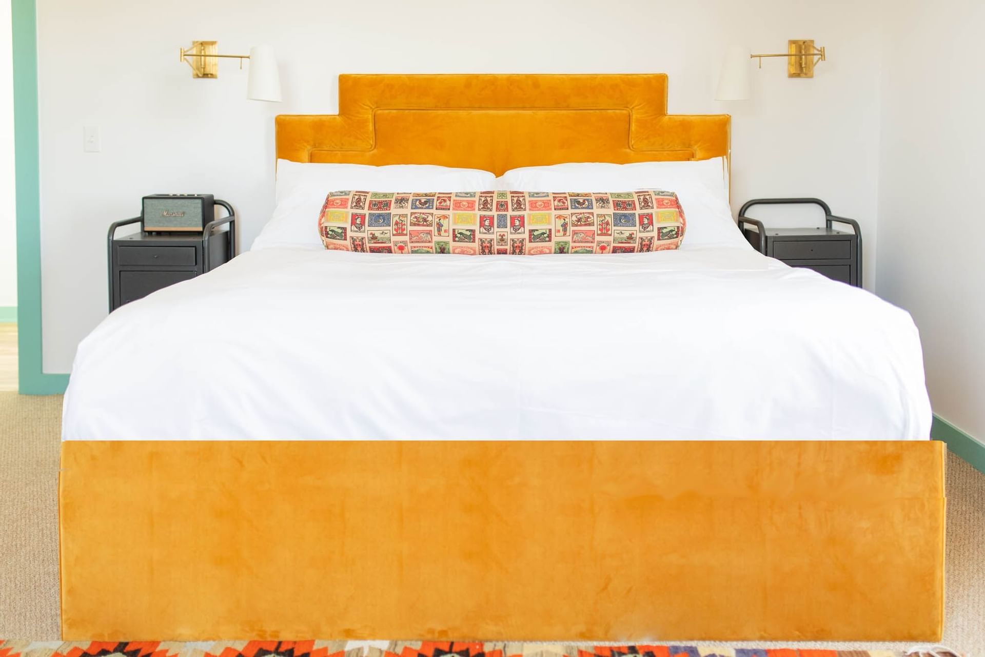 bed with orange bedframe in white room