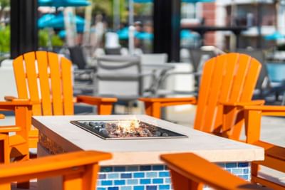 Orange chairs surround a fire pit at Vista Cay Resort By Millenium