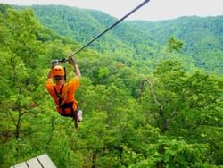 A man on a zipline at The Gorge Zipline near Mountain Inn & Suites