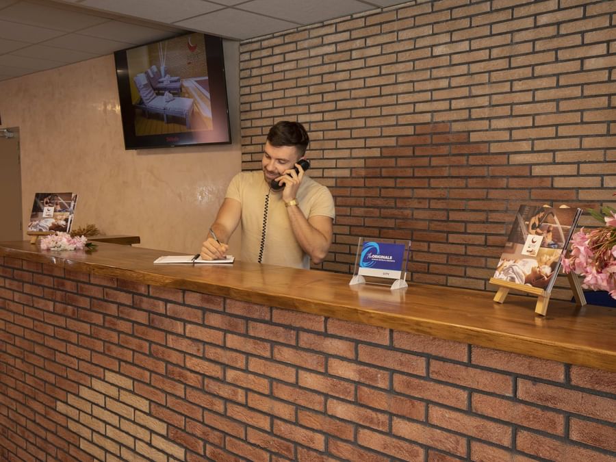 A receptionist at the reception desk in Relax'Otel