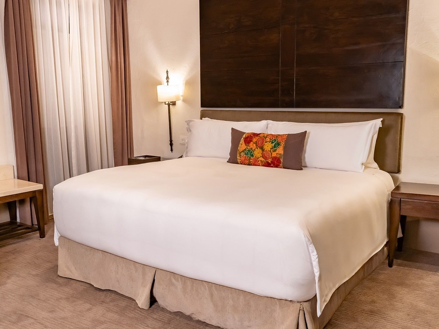 King bed with white linens and a colorful accent pillow in the King Presidential Suite at Quinta Real Puebla