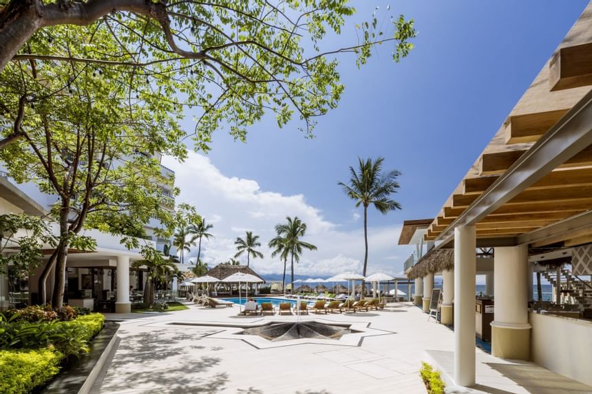 sillas y mesas alrededor de la piscina de un hotel