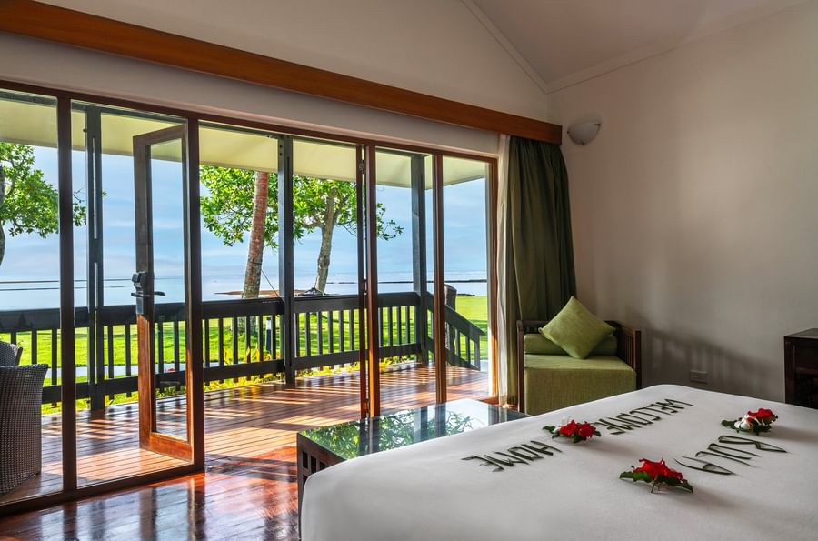 Bedroom with ocean view through sliding doors at The Naviti Resort Fiji.