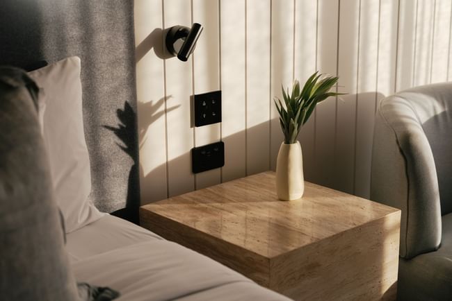 Ceramic vase with palm leaves on a stone bedside table at Elysium Hotels, the best 5-star hotels in New South Wales