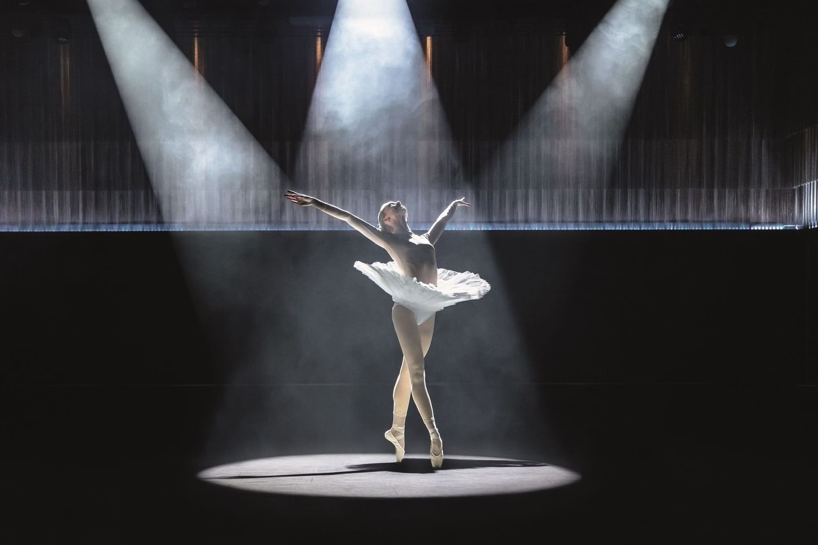 Elegant ballerina performing on stage with spot lighting at The Londoner Hotel