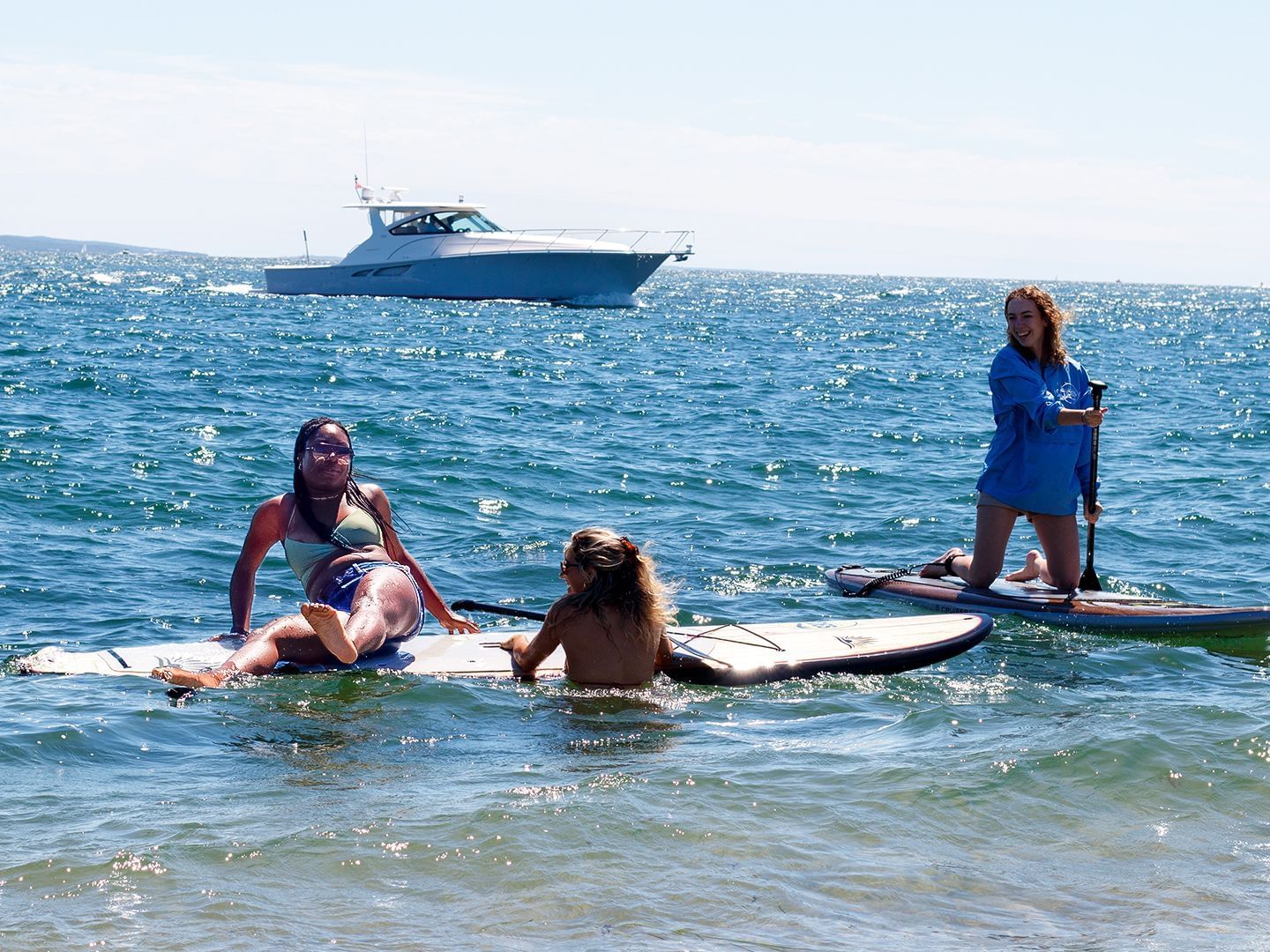 A group of friends paddle boating near Falmouth Tides