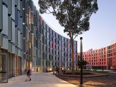 Modern student housing with vibrant facades and people walking at La Trobe University.