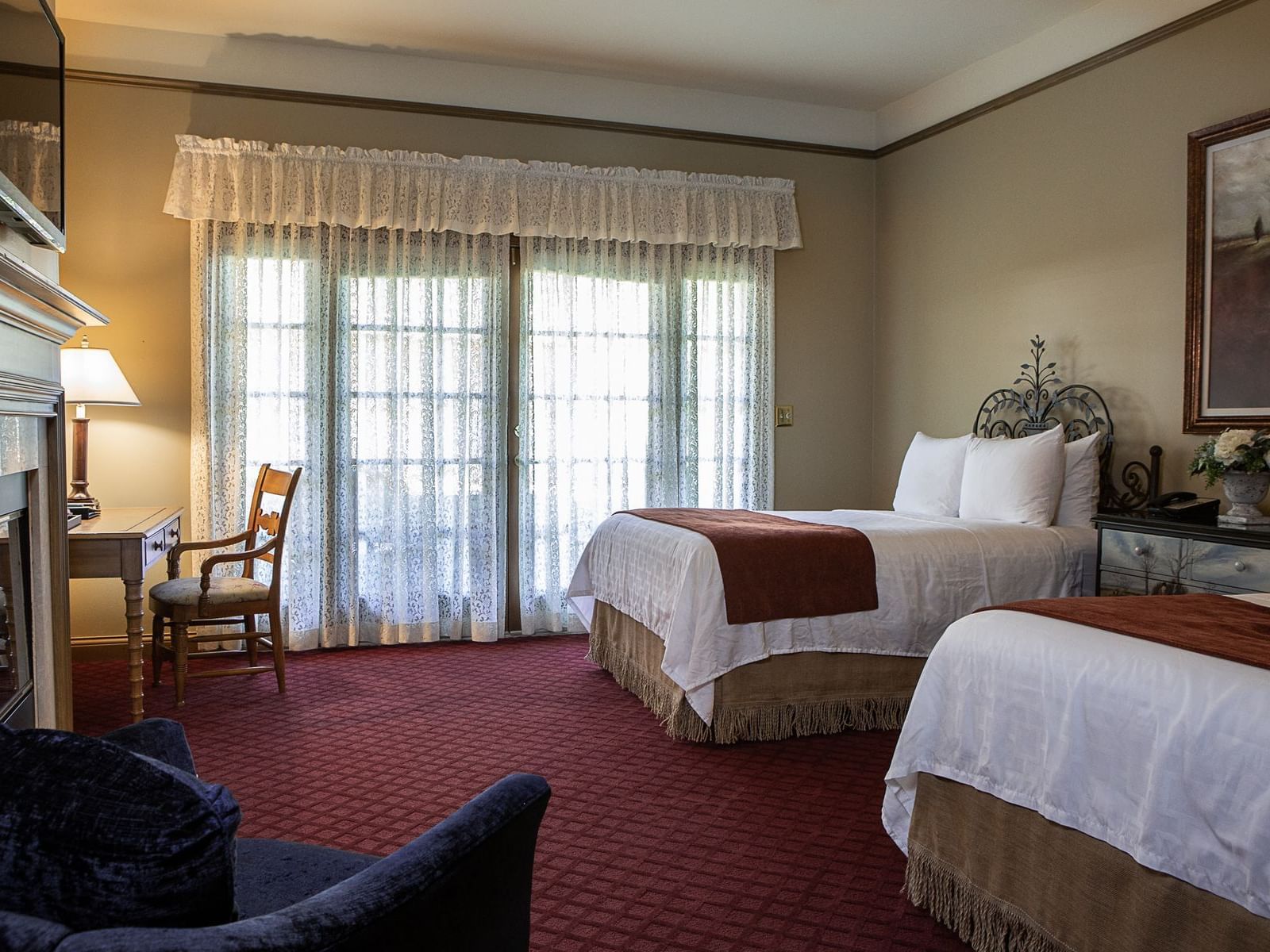 two beds and a chair in a hotel room