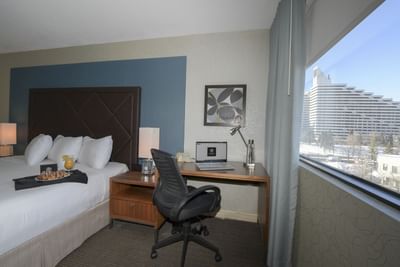 Desk and chair by window in king bed guest room.