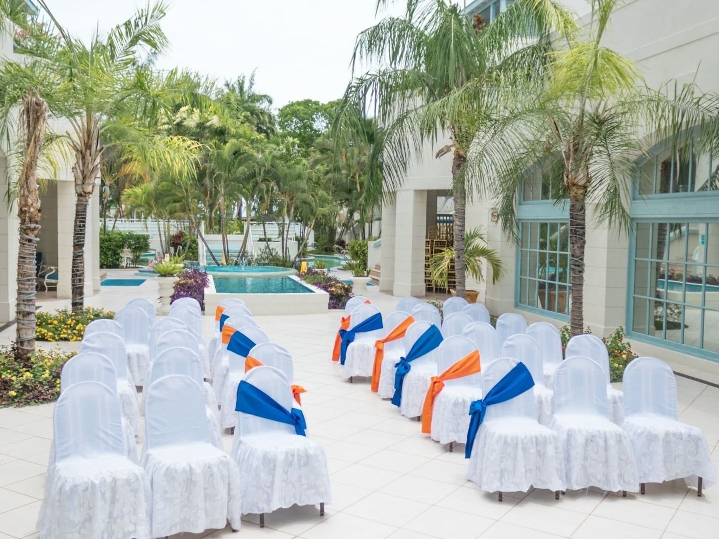 Chairs draped in white with blue and orange ribbons set up in rows at Savannah Beach Hotel.
