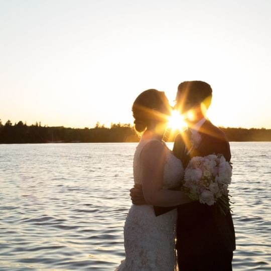 Bride and groom kissing by the lake at Chase on The Lake
