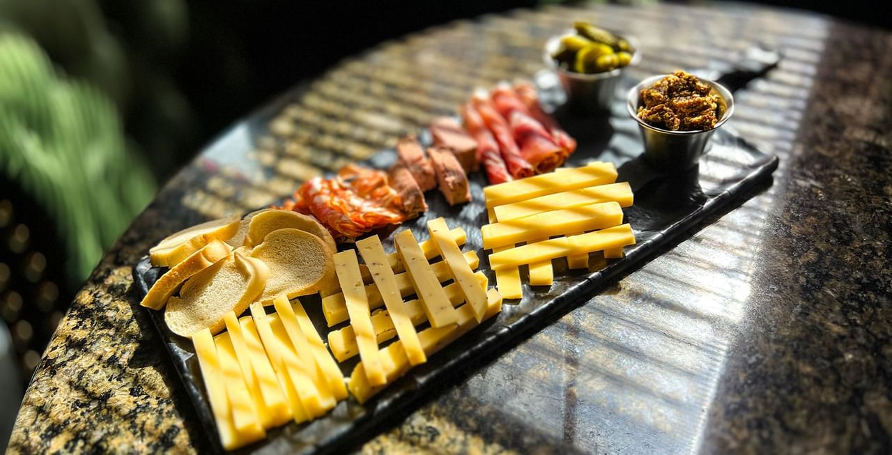 Close-up of charcuterie board with cheese, curated meat, and bread served at Midnight Sun, a Coast Hotel