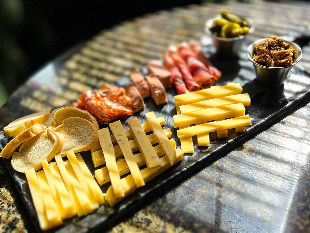 Close-up of charcuterie board with cheese, curated meat, and bread served at Midnight Sun, a Coast Hotel
