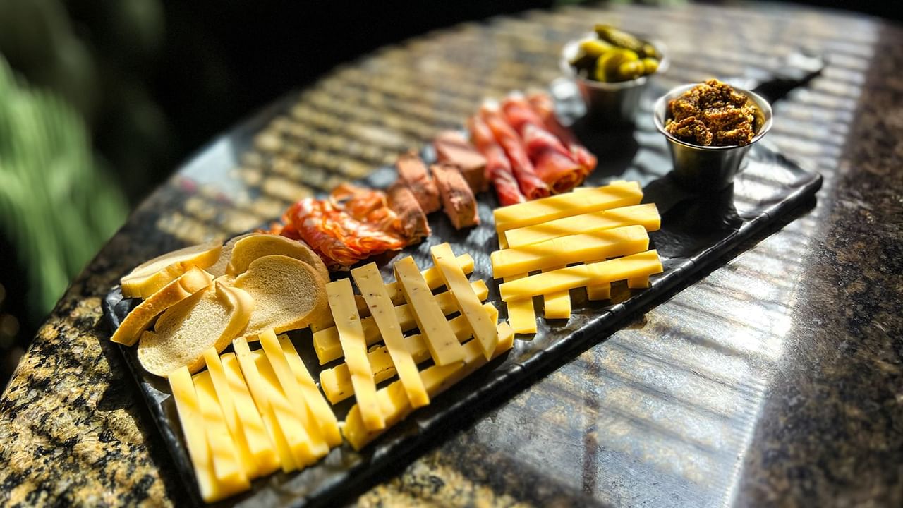 Close-up of charcuterie board with cheese, curated meat, and bread served at Midnight Sun, a Coast Hotel