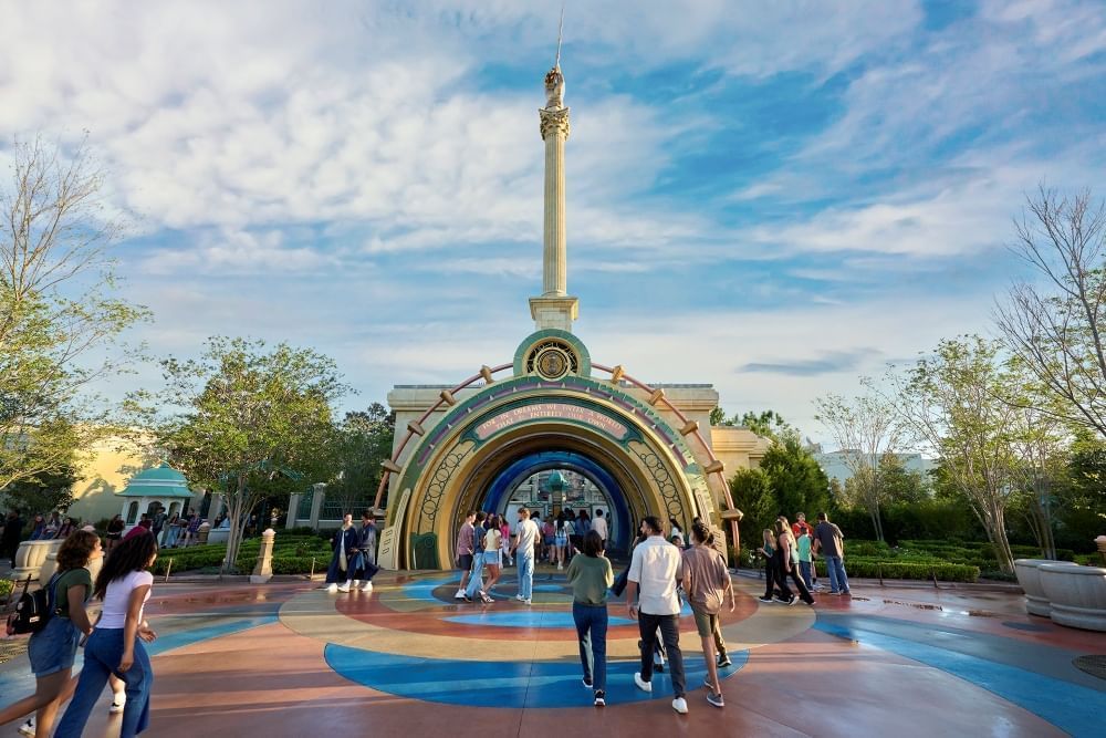 An ornate archway with a tall column, at the top of which is a hand holding a wand.