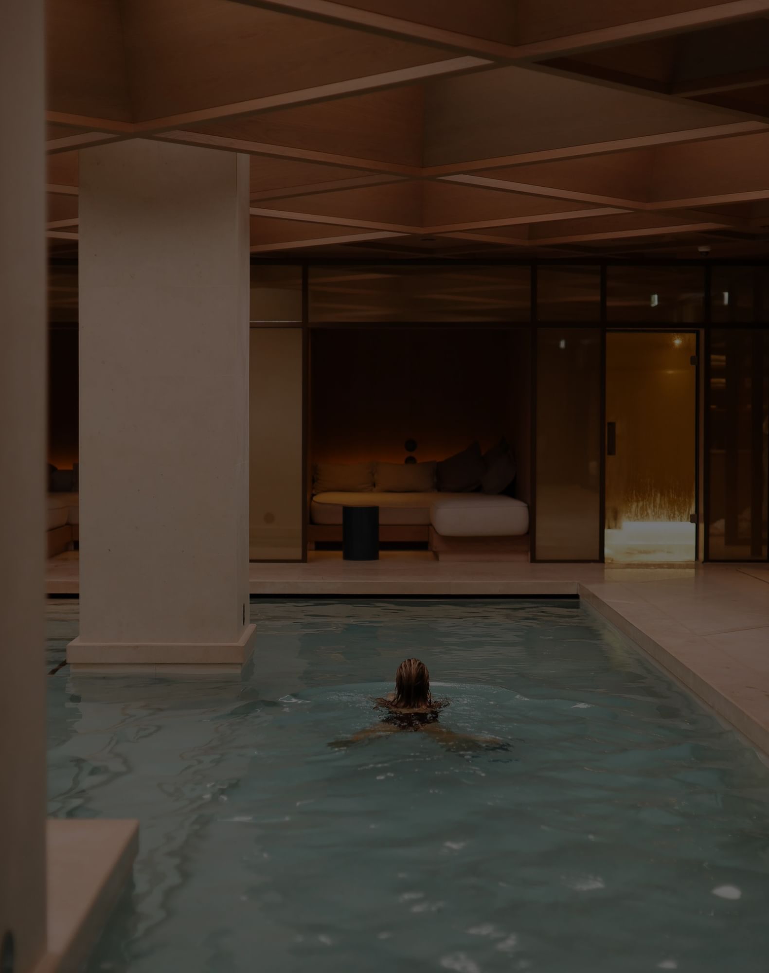 Women swimming in an indoor pool at The Londoner Hotel