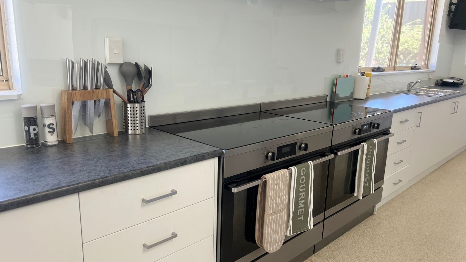 La Trobe University - Orde House kitchen with black oven, white cabinets, and Gourmet towels.
