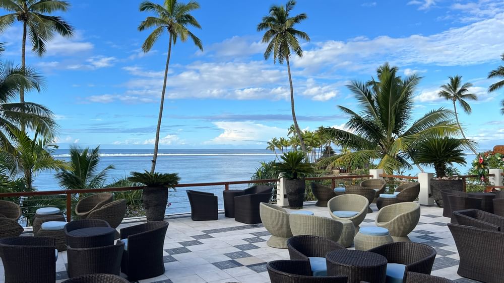 Outdoor seating area with ocean view at Sunset Terrace Bar at Warwick Fiji Resort and Spa, Korolevu.