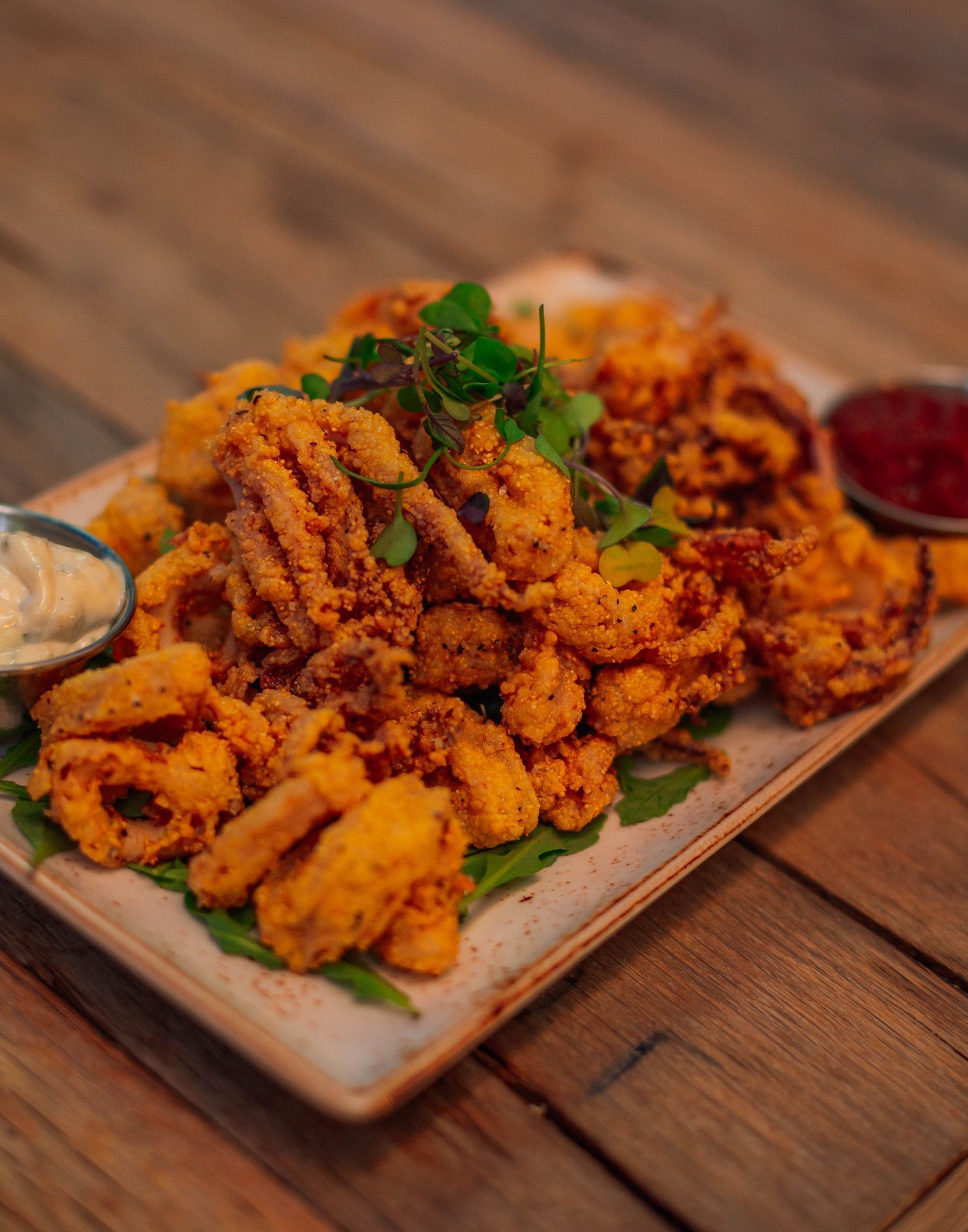 Lorem ipsum Plated fried calamari pieces with red and white dipping sauces