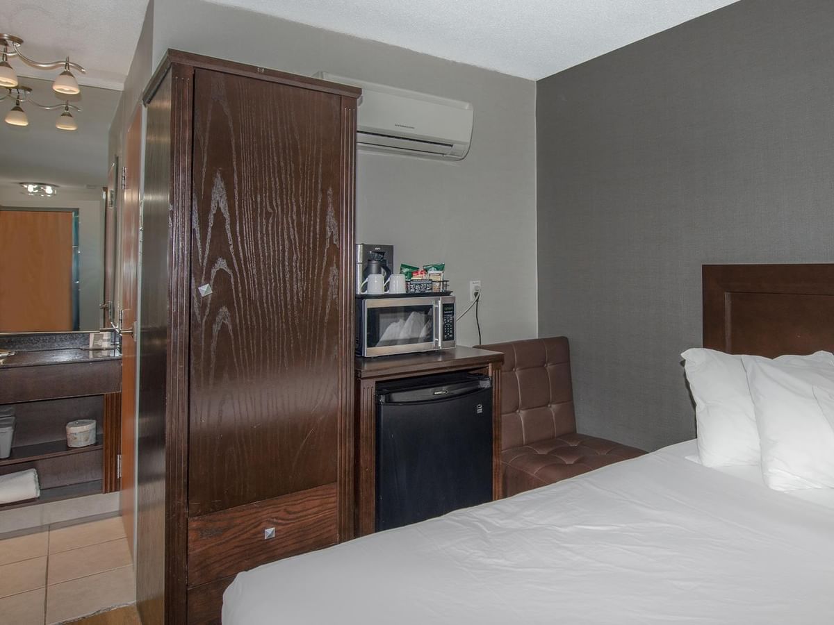 Bed, microwave, and mini fridge in a hotel room.