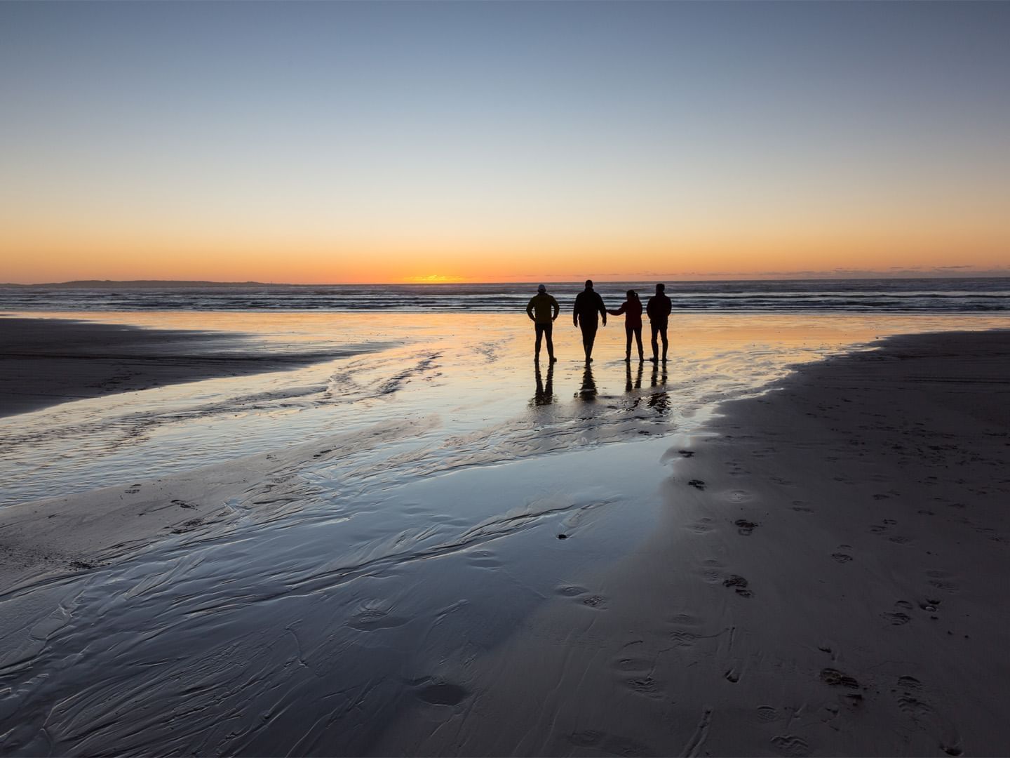 People enjoying the sunset on the beach near Strahan Village