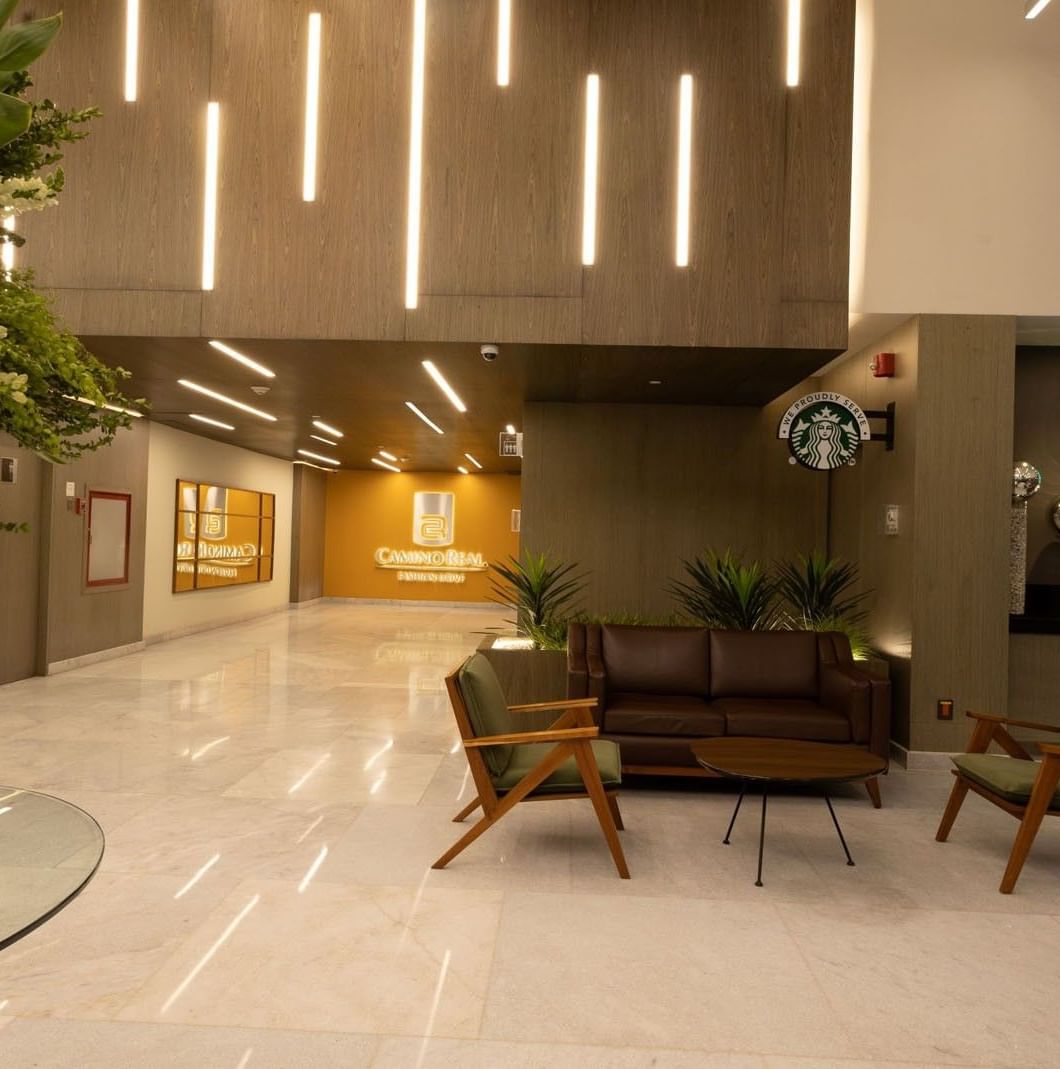 Restaurant entrance with wood paneling, seating, and floral displays at Camino Real Fashion Drive, Monterrey