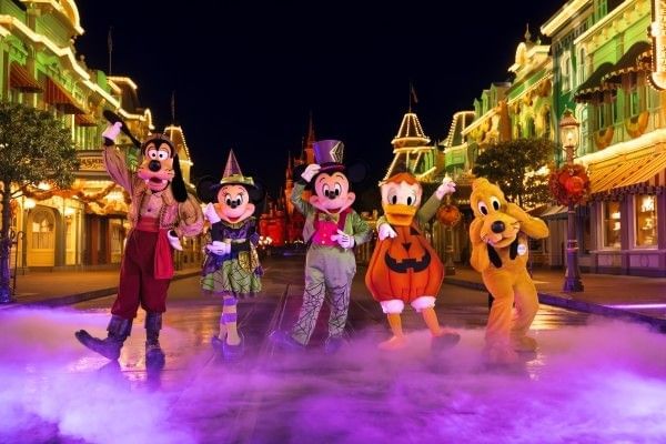 Goofy, Minnie, Mickey, Donald, and Pluto stand on Main Street in Magic Kingdom, wearing Halloween costumes.
