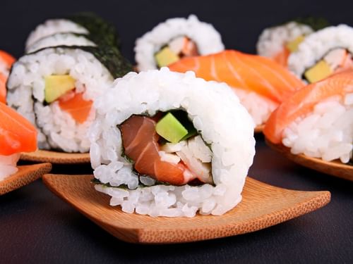 Plato de rollos de sushi de salmón y aguacate en pequeños platos de madera en La Terraza del Santo de Hacienda Del Mar Los Cabos