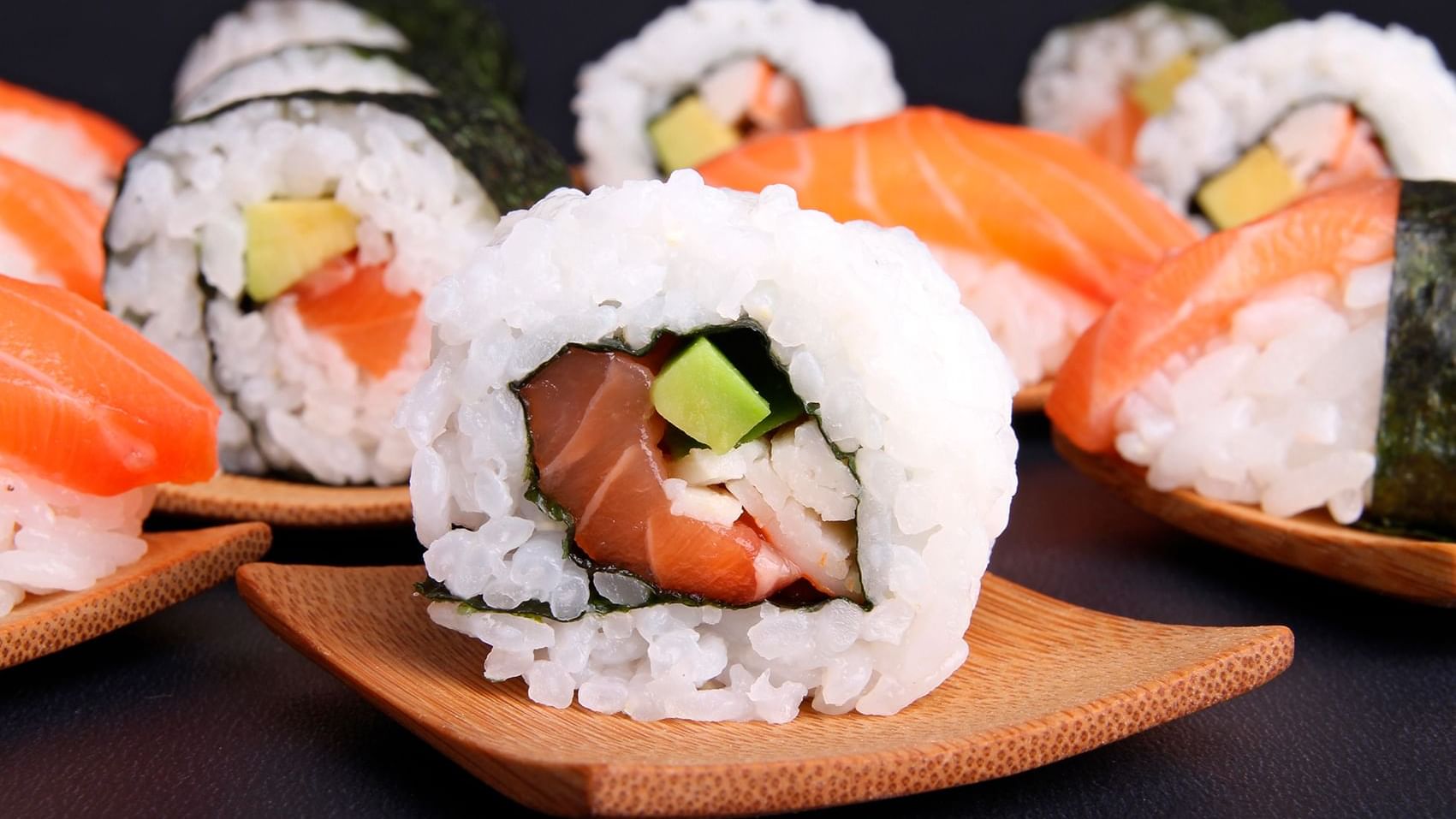 Plato de rollos de sushi de salmón y aguacate en pequeños platos de madera en La Terraza del Santo de Hacienda Del Mar Los Cabos