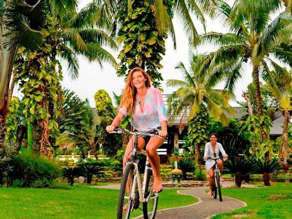 Women riding bicycles in a pathway at The Warwick Fiji