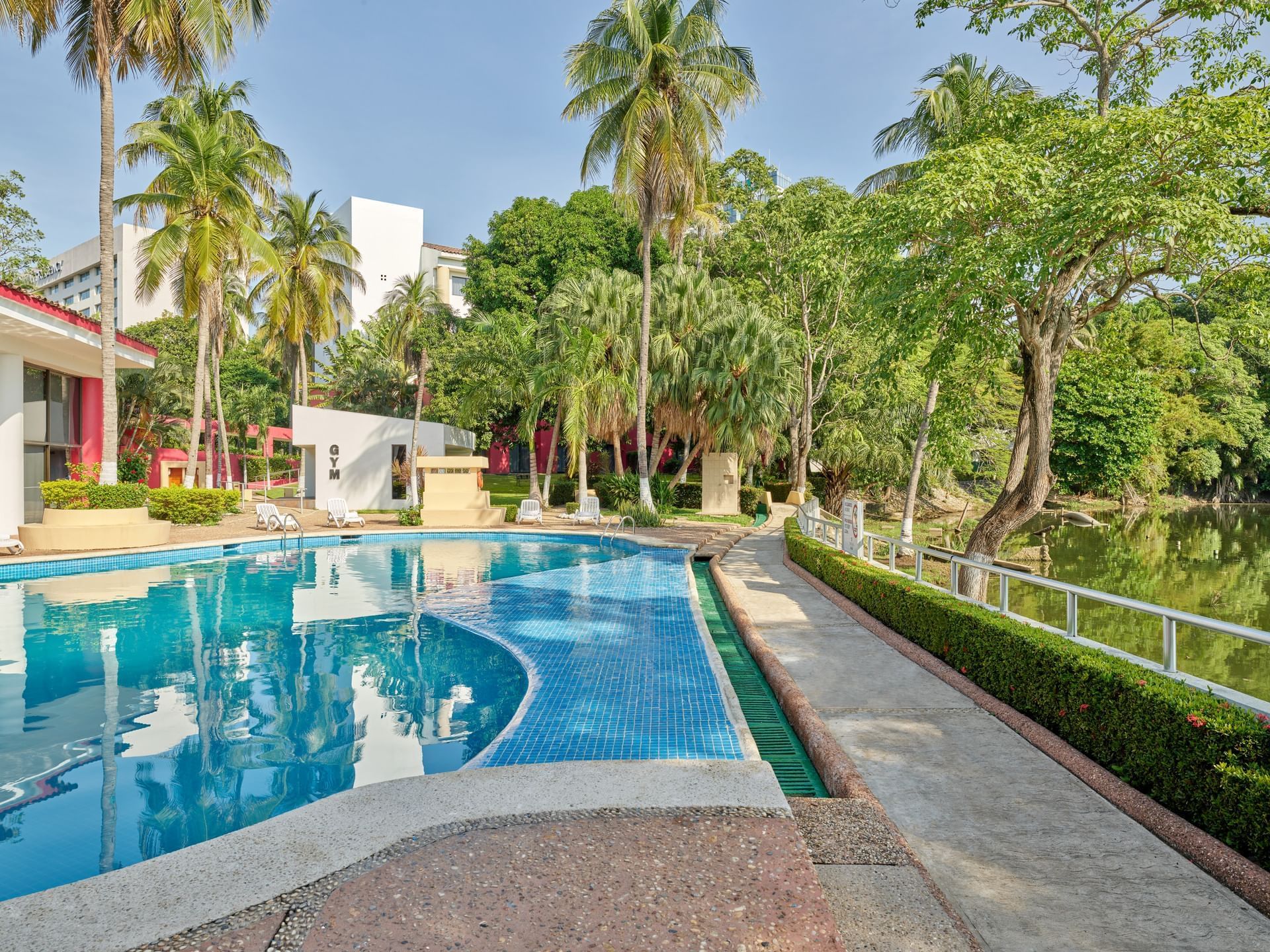 Outdoor swimming pool with a garden view at Fiesta Inn Hotels
