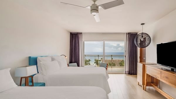 3 Bedrooms Family Suite featuring two beds, modern decor, and a balcony with an ocean view at Fiesta Americana