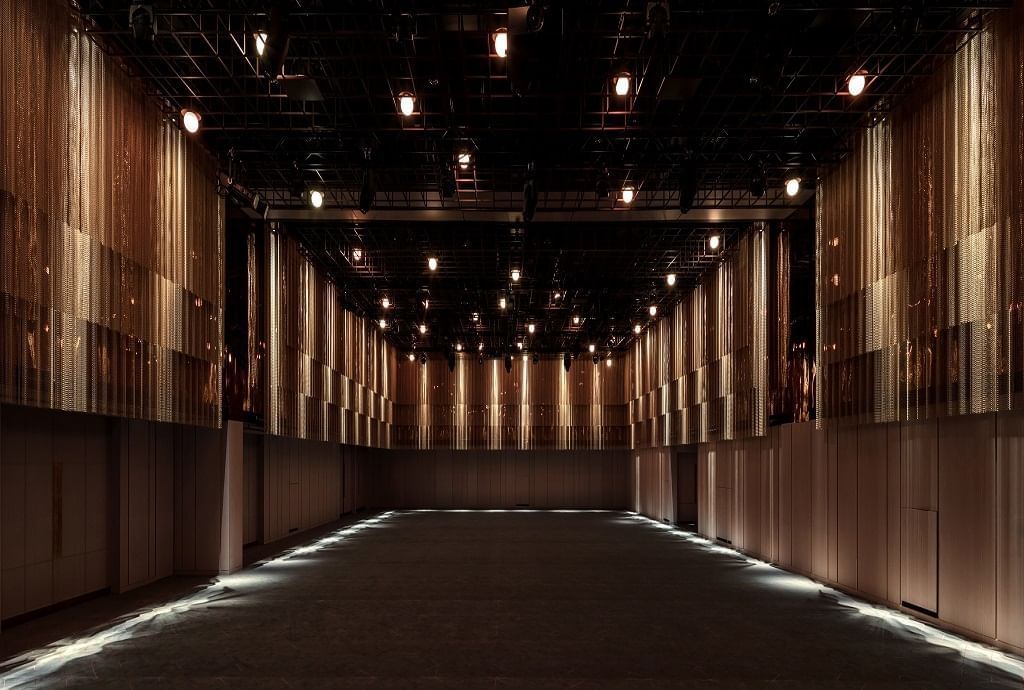 A spacious, modern event hall with intricate lighting and minimalist design, perfect for functions at The Londoner Hotel