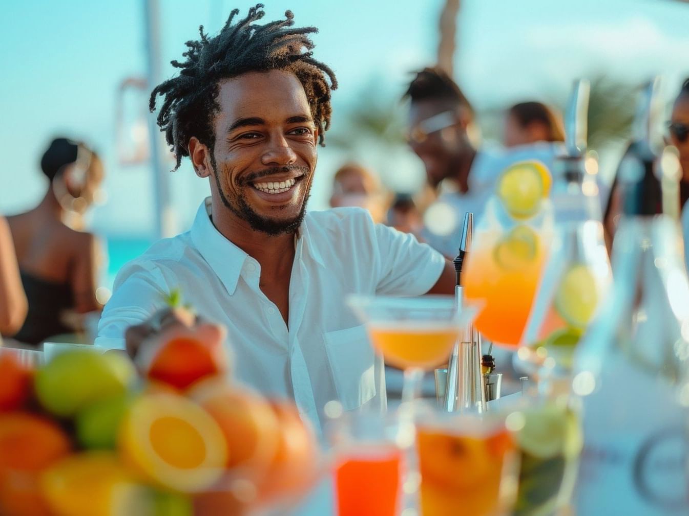 Un barman sonriente prepara cócteles de frutas para los huéspedes en un bar soleado cerca de Fiesta Americana Funeeq