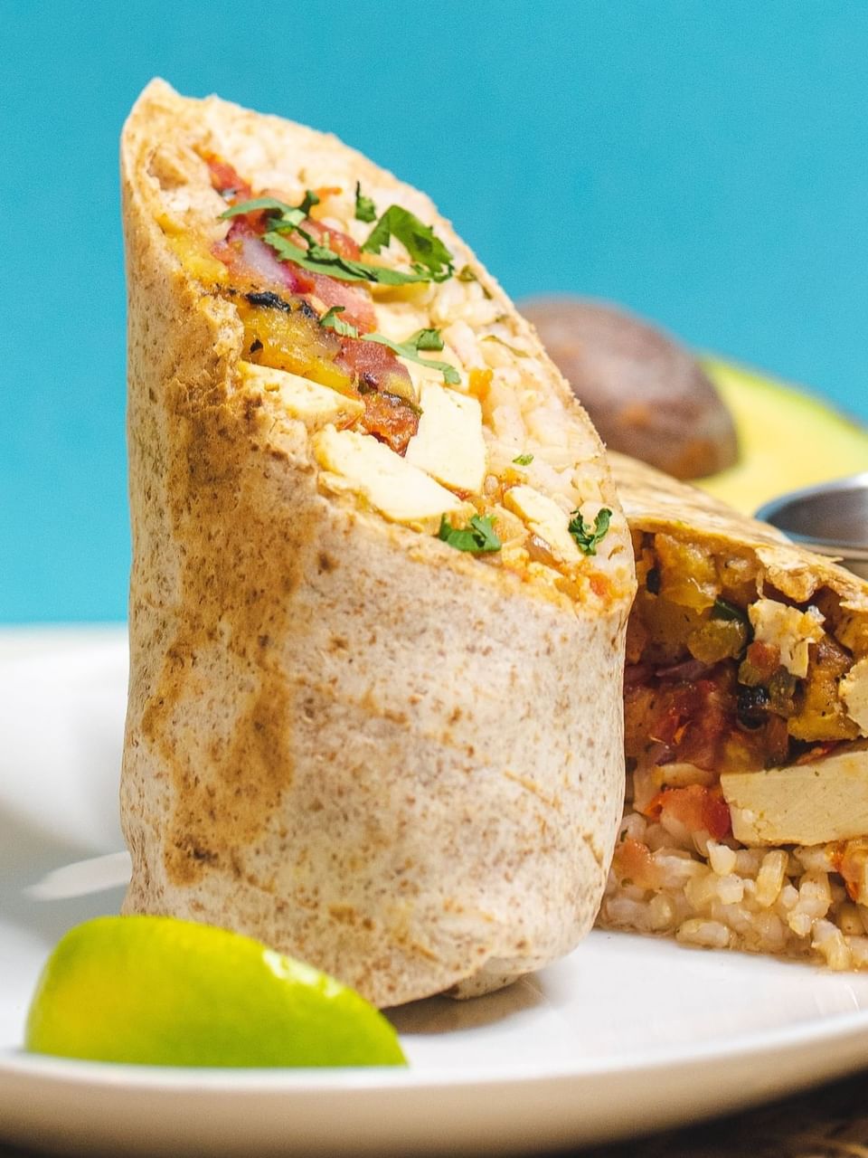 A close-up of a stuffed burrito with tofu, rice, and vegetables featuring La Ezkina restaurant at El Conquistador Resort