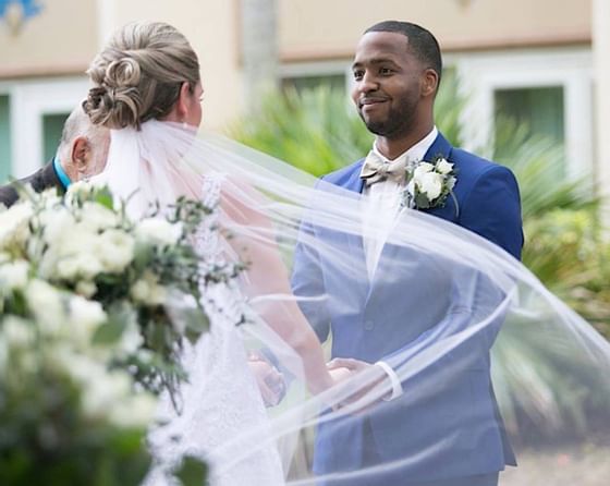 Happy couple holding hands during wedding ceremony.