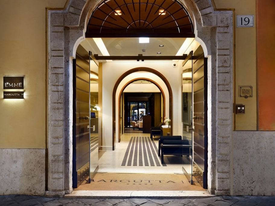 Entrance of Margutta 19 with illuminated hallway by the lobby lounge area