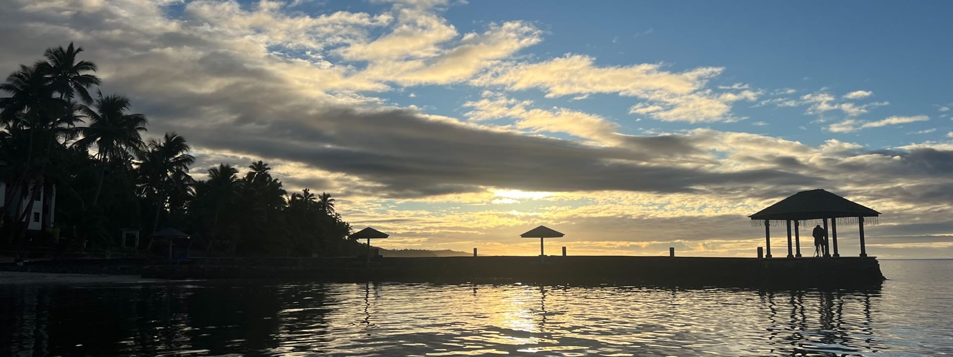 Sunset over serene waters and palm trees at Warwick Fiji Resort and Spa in Korolevu