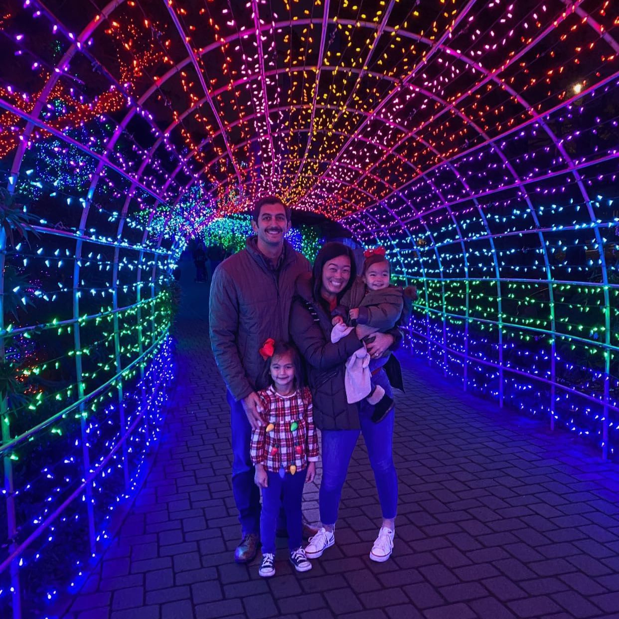Family photo under the rainbow tunnel at Cambria Christmas Market
