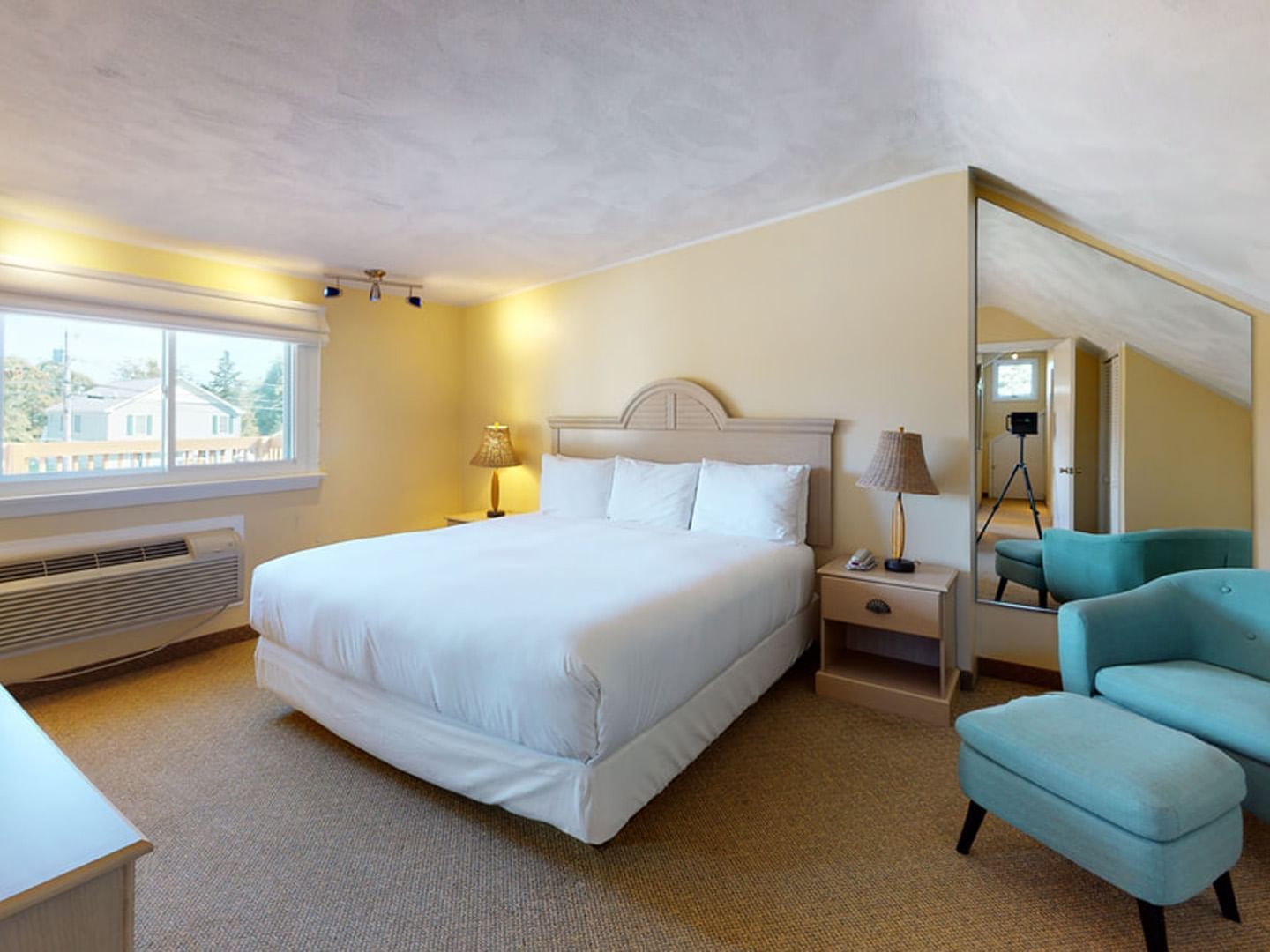 Bed with table lamps by the window and couch in Main House Two Bedroom at Breezeway Boutique Hotel