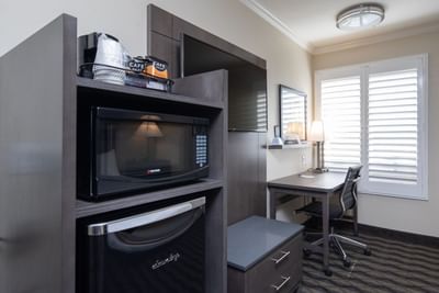 a microwave and mini fridge next to a TV